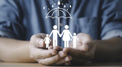 Businessman hands protecting a family under an umbrella symbol representing insurance safety security care support and risk management for health life and family protection concept.